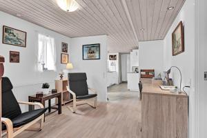 a living room with white walls and a wooden ceiling at Guldbergs Guesthouse in Kerteminde