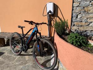 una bicicletta è parcheggiata accanto a un muro di Agriturismo Gli Ulivi a Garlenda