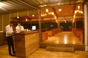 twee mannen staan aan een bar in een schuur bij ZESTCLUB in Gulbarga