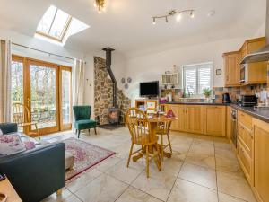 Appletree Cottage في Kirkton of Tealing: مطبخ وغرفة معيشة مع طاولة وكراسي