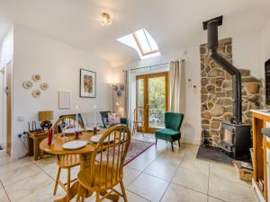 uma sala de jantar com uma mesa e um fogão a lenha em Appletree Cottage em Kirkton of Tealing