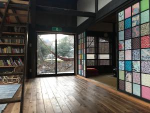 una habitación con vidrieras en una casa en Yokomura Eco-Lodge en Uenohara