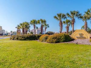 a park with palm trees and a sign in the grass at Seahawk South B in Fort Morgan
