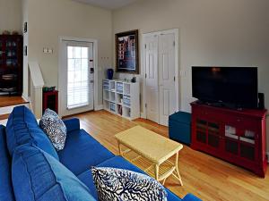a living room with a blue couch and a tv at Seahawk South B in Fort Morgan