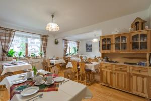 a dining room with tables and chairs and a kitchen at Gościniec Regionalny in Zakopane