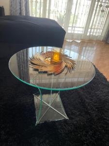 una mesa de centro de cristal con una tapa de cristal sobre una alfombra en lii homes, en Kampala