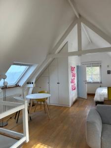 Loft con cama y mesa en una habitación en Le Cottage, en Lasne