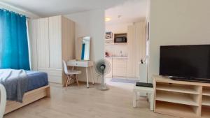 a bedroom with a bed and a flat screen tv at Elio Del Ray in Bangkok