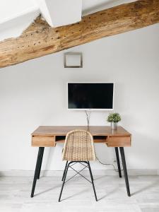 Cette chambre comprend un bureau avec une télévision et une chaise. dans l'établissement Outsite Biarritz, à Biarritz