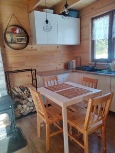 kuchnia i jadalnia ze stołem i krzesłami w obiekcie Markowa Chata w Cisnej