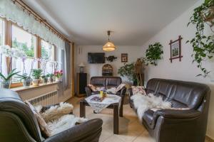a living room with leather couches and a table at Gościniec Regionalny in Zakopane