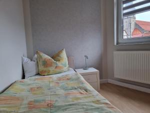 a bedroom with a bed with pillows and a window at Ferienwohnung Am Anger in Diedorf