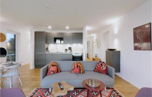 ein Wohnzimmer mit einer blauen Couch und einer Küche in der Unterkunft Beach Front Apartment in Lembruch