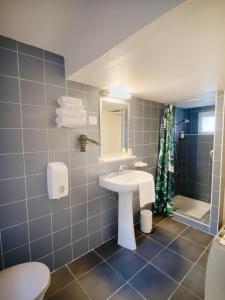 La salle de bains est pourvue d'un lavabo, de toilettes et d'une douche. dans l'établissement Outsite Biarritz, à Biarritz