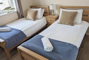 een slaapkamer met 2 bedden en handdoeken bij Atlantic Escape - Near Beaches and Padstow, Garden, Private Parking in Padstow
