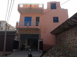 a pink house with a motorcycle parked in front of it at DIPEN GUEST HOUSE in Alwar