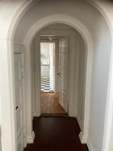 an archway leading to a hallway with a tile floor at Store Sand in Vemb