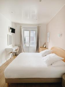 - une chambre avec un grand lit blanc et un bureau dans l'établissement Outsite Biarritz, à Biarritz