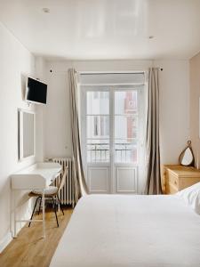 - une chambre avec un lit, un bureau et une fenêtre dans l'établissement Outsite Biarritz, à Biarritz