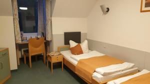 a small room with a bed and a desk at Hotel Regenbogenhaus in Freiberg