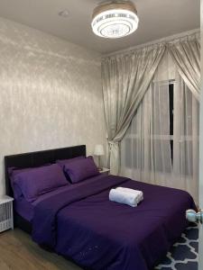 a bedroom with a purple bed and a chandelier at Sofia Homestay Cerrado Southville City Bangi Netflix Wifi in Kampong Tangkas