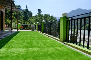 a balcony with green railings and a view of the water at Himalaya Heaven Homestay in Tharāli