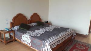 a bedroom with a large bed with a wooden headboard at Himalaya Heaven Homestay in Tharāli