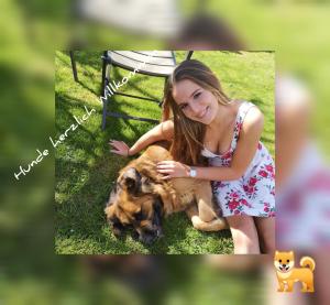 a young girl petting a dog in the grass at diemelseeholiday romantisches Ferienhaus im Sauerland Nähe Willingen Winterberg in Diemelsee