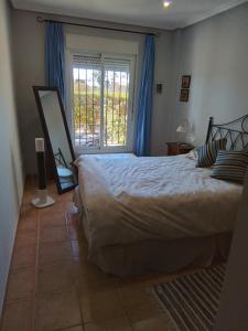 een slaapkamer met een groot bed en een raam bij THALLASA APARTMENT VERA PLAYA in Playas de Vera