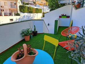 Apartamento "La Viña" في مالقة: شرفة مع طاولة وكراسي والنباتات