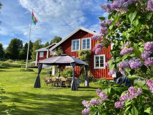 a red house with a picnic table and a flag at Pelle Åbergsgården in Nordingrå