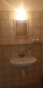 a white sink in a bathroom with a light at Restaurace a penzion Ubrousku prostři se in Nová Bystřice
