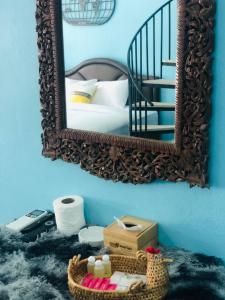 a mirror on a blue wall with a bed and a basket at กอบสุข รีสอร์ท2 k02 in Ban Ton Liang