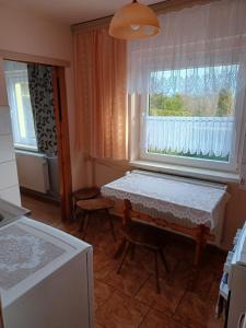 eine Küche mit einem Tisch und einem Fenster in der Unterkunft Domek u Piotra koło Szczyrku in Kalna