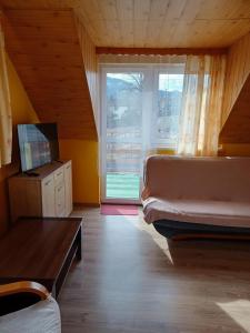 ein Schlafzimmer mit einem Bett und einem großen Fenster in der Unterkunft Domek u Piotra koło Szczyrku in Kalna