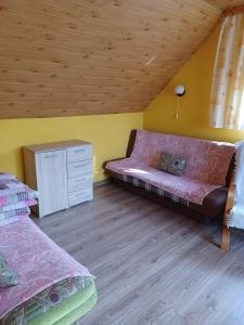 a bedroom with a couch and a wooden ceiling at Domek u Piotra koło Szczyrku in Kalna
