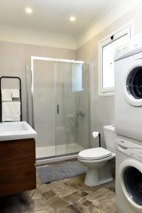 a bathroom with a shower toilet and a washing machine at Katerina's Place in Argos