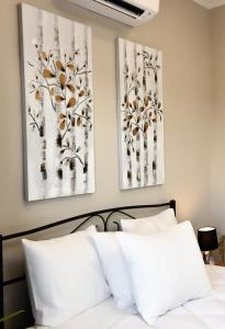 a bedroom with two paintings of trees on the wall at Katerina's Place in Argos