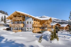 a log home in the snow at Appartement Hofmann in Königsleiten