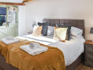 een slaapkamer met een groot bed en handdoeken bij Skylarks Nest in Witton