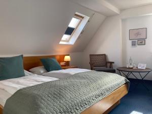 een slaapkamer met een groot bed en een dakraam bij Gasthaus zum Schwan in Castell