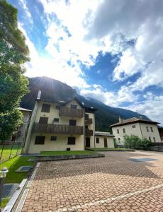 a building with a mountain in the background at Bianchina - Bilocale con giardino privato in Valdisotto