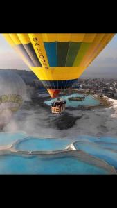 een heteluchtballon die over een hoop water vliegt bij OzenTurku Hotel in Pamukkale