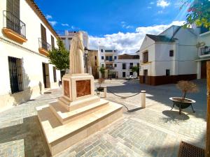 a statue in the middle of a courtyard with buildings at Dúplex Centro Écija in Écija