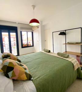 a bedroom with a large green bed with pillows at Dúplex en pleno centro de Écija in Écija