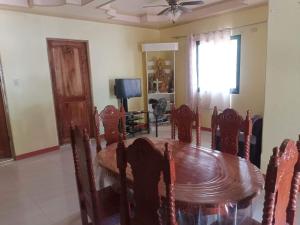 una sala da pranzo con tavolo e sedie in legno di Victoria Alaminos property a Alaminos
