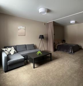 a living room with a couch and a bed at Vėtrungės Apartamentai in Klaipėda