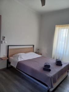Poros Seaside Suite في بوروس: غرفة نوم بها سرير وعليه قبعتين