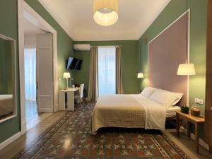- une chambre avec un lit et un mur vert dans l'établissement Bed in Spa, à Palerme