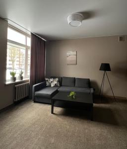 a living room with a couch and a table at Vėtrungės Apartamentai in Klaipėda
